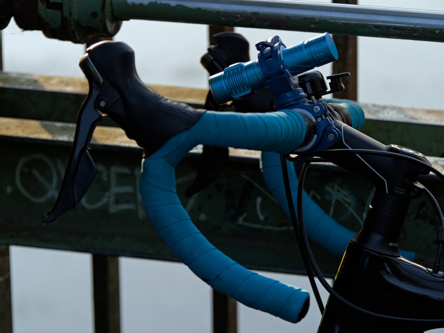 A Convoy S21E flashlight clamped to the handlebars of a road bike